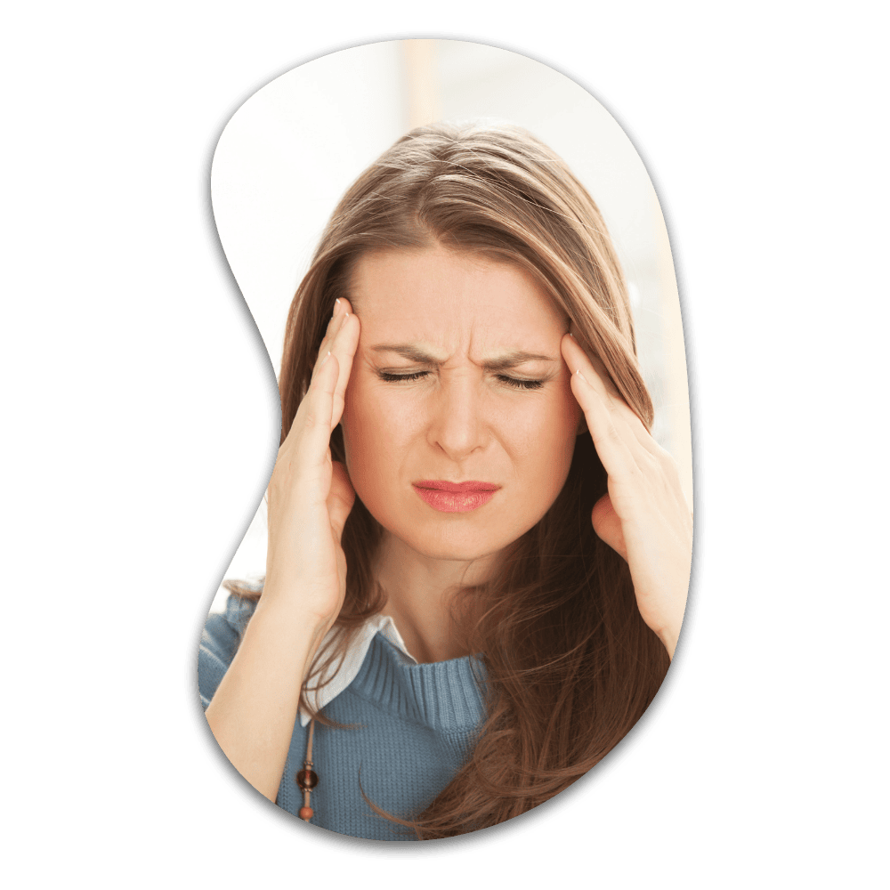 Woman with brown hair wearing a blue top, holding her head with both hands and wincing in pain or distress