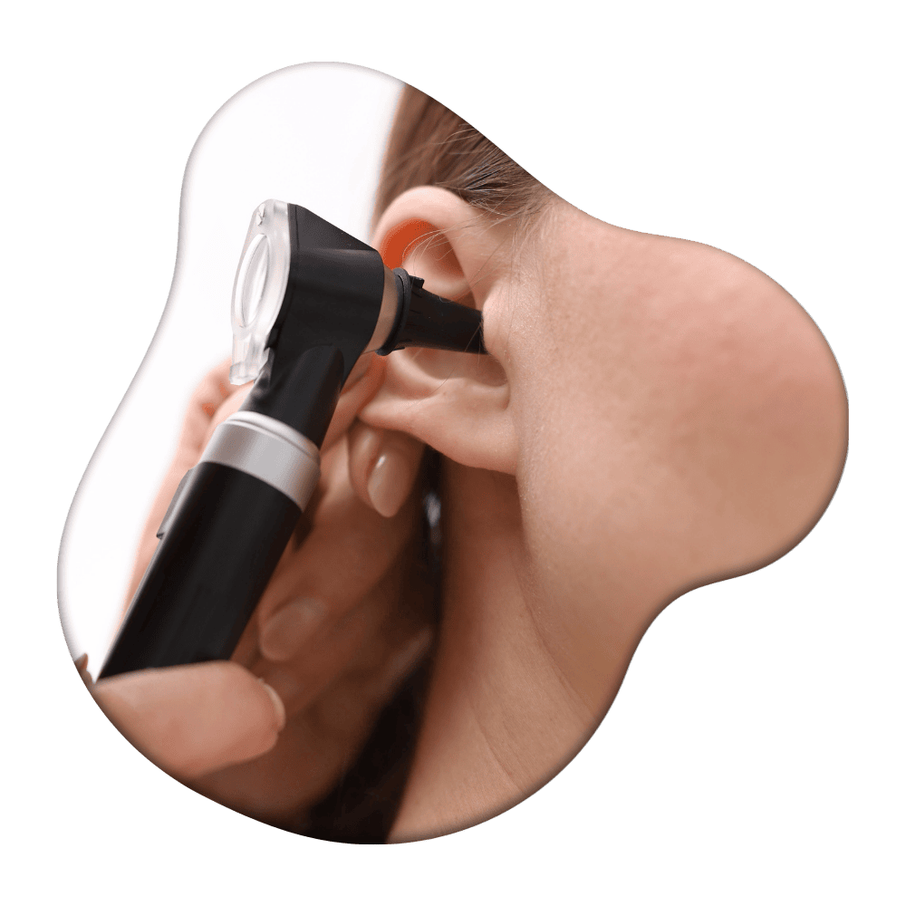 Person holding a black and white digital otoscope to their ear for examination or hearing assessment